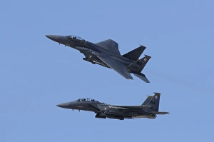 A pair of F-15C Eagle aircraft perform maneuvers at an airshow A pair of F-15C Eagle aircraft perform maneuvers at an airshow