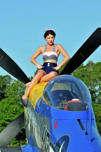 Retro Swimwear Fashion Prints: Retro beauty in a vintage style bathing suit sitting on the nose of a P-51 Mustang