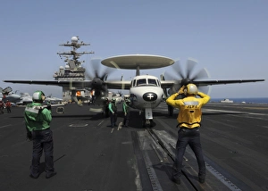 A plane director guides an E-2C Hawkeye onto the catapult for launch A plane director guides an E-2C Hawkeye onto the catapult for launch