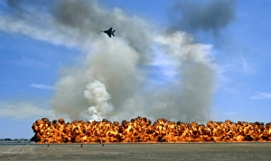 Pyrotechnics explode while an F-15 flies over to simulate an air-to-ground attack Pyrotechnics explode while an F-15 flies over to simulate an air-to-ground attack