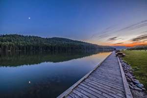 Quarter moon reflected in the waters of Reesor Lake, Alberta, Canada Quarter moon reflected in the waters of Reesor Lake, Alberta, Canada