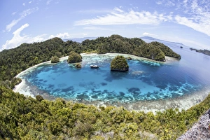 Rugged limestone islands surround a lagoon in Raja Ampat Rugged limestone islands surround a lagoon in Raja Ampat