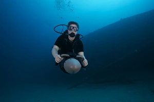 Scuba diver uses a diver propulsion vehicle to navigate the Hilma Hooker shipwreck Scuba diver uses a diver propulsion vehicle to navigate the Hilma Hooker shipwreck