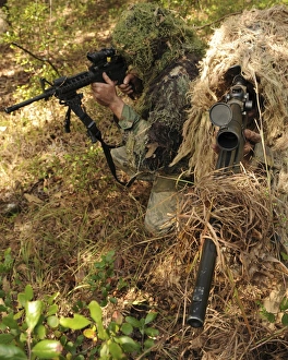 Sharpshooters sneak through the forest in their ghillie suits Sharpshooters sneak through the forest in their ghillie suits