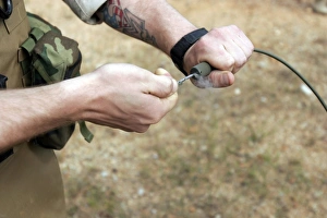 A soldier pulls a detonation cord igniter to start a reaction detonating C-4 explosives A soldier pulls a detonation cord igniter to start a reaction detonating C-4 explosives