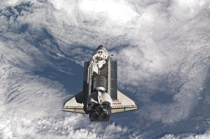 Space shuttle Atlantis above a cloud covered Earth Space shuttle Atlantis above a cloud covered Earth