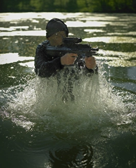 Special operations forces soldier emerges from water armed with a Steyr AUG assault rifle Special operations forces soldier emerges from water armed with a Steyr AUG assault rifle