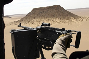 A UH-60 Blackhawk crew chief holds an M240G medium machine gun A UH-60 Blackhawk crew chief holds an M240G medium machine gun