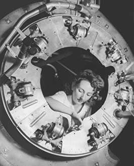 A woman assembles part of the cowling of a B-25 bomber motor. circa 1942 A woman assembles part of the cowling of a B-25 bomber motor. circa 1942