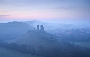 Corfe Castle, sunrise and early morning mist, view from West Hill, Corfe, Dorset, England Corfe Castle, sunrise and early morning mist, view from West Hill, Corfe, Dorset, England