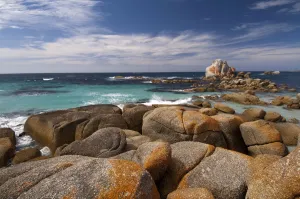 Headland coastline clad in granite boulders covered in red lichen, Mount William National Park Headland coastline clad in granite boulders covered in red lichen, Mount William National Park