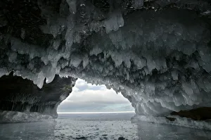 Ice hanging from arch in sea cave carved in soft sandstone cliffs, frozen lake, Squaw Bay Ice hanging from arch in sea cave carved in soft sandstone cliffs, frozen lake, Squaw Bay