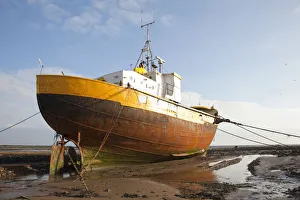 Old fishing boat held upright at low tide with ropes and chains, Roa Island, Morecambe Bay Old fishing boat held upright at low tide with ropes and chains, Roa Island, Morecambe Bay