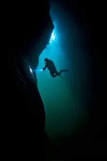 Scuba diver exploring a sea cave beneath Giants Legs, Bressay, Shetland Islands, Scotland Scuba diver exploring a sea cave beneath Giants Legs, Bressay, Shetland Islands, Scotland