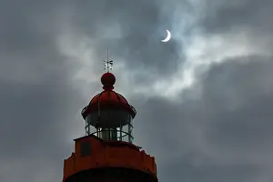 Brittany Coast Scenery Prints: Solar eclipse in a cloudy sky above the lighthouse at Pointe Saint-Mathieu