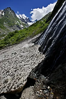 Water flowing down a rock face and underneath a glacier, Amanauz Valley near Dombay Water flowing down a rock face and underneath a glacier, Amanauz Valley near Dombay
