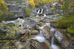 Waterfall cascading through rocky gorge in autumn, Stor-Elvdal, near Rondane National Park Waterfall cascading through rocky gorge in autumn, Stor-Elvdal, near Rondane National Park