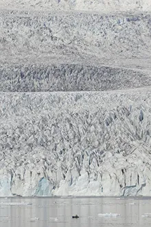 Zodiac carrying visitors navigating among ice floes at foot of Fjallsarlon Glacier, Iceland. July Zodiac carrying visitors navigating among ice floes at foot of Fjallsarlon Glacier, Iceland. July