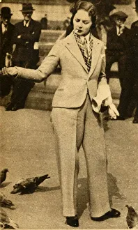 A betrousered lady feeding pigeons in Trafalgar Square, 1933. Creator: Unknown A betrousered lady feeding pigeons in Trafalgar Square, 1933. Creator: Unknown