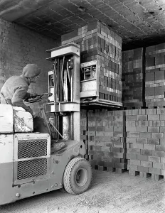 Michael Walters Photography UK Prints: A yardsman stacking pallets of bricks