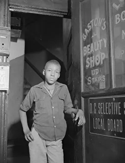 Youth waiting for a newspaper delivery truck, Washington, D.C. 1942. Creator: Gordon Parks Youth waiting for a newspaper delivery truck, Washington, D.C. 1942. Creator: Gordon Parks