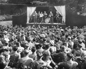 Print of soldiers on stage entertaining fellow troops, 9 October 1939