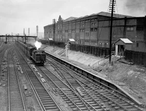 Prints of Manchester United grandstand platform under construction, with steam train passing Old Trafford Main Stand and the train station around the time it was built in 1935 Manchester Prints: 1935 Train Print: Old Trafford Football Ground