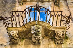 Baroque balcony railing with carved stone supports in Ragusa in Sicily, Italy Baroque balcony railing with carved stone supports in Ragusa in Sicily, Italy