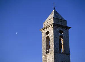 The Belltower Of The Church Of Santo Stefano Di Sessanio With The Moon Behind At Dusk The Belltower Of The Church Of Santo Stefano Di Sessanio With The Moon Behind At Dusk