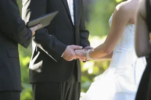 A Bride And Groom Holding Hands During Their Ceremony; Troutdale, Oregon, United States Of America A Bride And Groom Holding Hands During Their Ceremony; Troutdale, Oregon, United States Of America