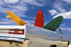 Colorful Surfboards In Vintage Plymouth Fury, Puffy Clouds In Background Colorful Surfboards In Vintage Plymouth Fury, Puffy Clouds In Background