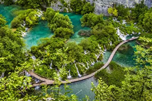 Footbridge crossing the turquoise lake water and waterfalls at the Plitvice Lakes National Park, Croatia Footbridge crossing the turquoise lake water and waterfalls at the Plitvice Lakes National Park, Croatia