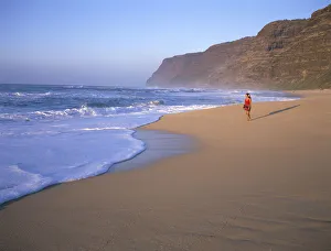 Hawaii, Kauai, Woman Walking Along Beach, Small Mountain, Blue Sky And Ocean Hawaii, Kauai, Woman Walking Along Beach, Small Mountain, Blue Sky And Ocean