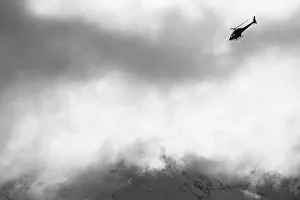 Heli Ski Helicopter Flying Amongst Fog And Clouds, New Zealand Heli Ski Helicopter Flying Amongst Fog And Clouds, New Zealand