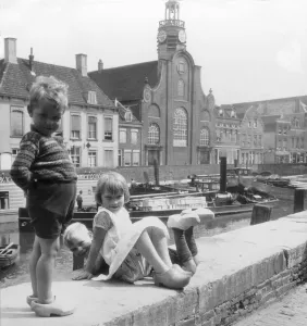 Historic image in black and white of children playing together along the canal in the Netherlands Historic image in black and white of children playing together along the canal in the Netherlands