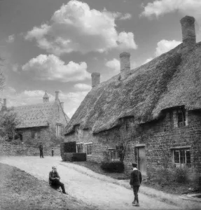 Historic image in black and white of thatched cottages and a church in a village in England, circa 1890; Swalcliffe Historic image in black and white of thatched cottages and a church in a village in England, circa 1890; Swalcliffe