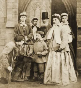 Historic image in sepia tone of a child begging for money outside the doorway of a church, with men and women watching Historic image in sepia tone of a child begging for money outside the doorway of a church, with men and women watching