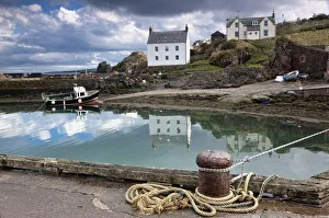 Houses And Boats Along The Water; Large Rocks In The Water Under Dark Clouds Houses And Boats Along The Water; Large Rocks In The Water Under Dark Clouds