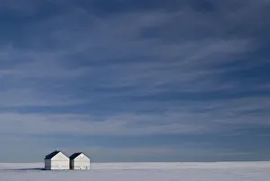 Hussar, Alberta, Canada; Two Small Farm Buildings In Flat Winter Landscape Hussar, Alberta, Canada; Two Small Farm Buildings In Flat Winter Landscape