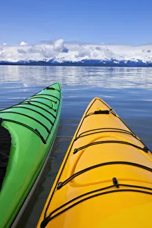 Kayakers enjoy a tranquil morning paddle in Lynn Canal, Alaska, near Juneau. Chilkat Mountains beyond Kayakers enjoy a tranquil morning paddle in Lynn Canal, Alaska, near Juneau. Chilkat Mountains beyond