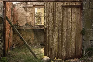 Northumberland, England; An Abandoned Building In Ruins With A Broken Wooden Door Northumberland, England; An Abandoned Building In Ruins With A Broken Wooden Door