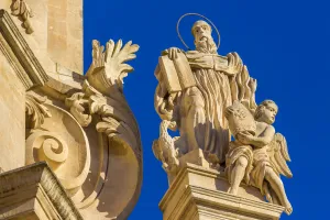 Ornate detail of mouldings and statue on the San Giuseppe Church against blue sky in Ragusa in Sicily, Italy Ornate detail of mouldings and statue on the San Giuseppe Church against blue sky in Ragusa in Sicily, Italy