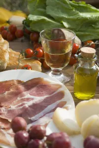 Prosciutto Ham, Cheese, Tomatoes, White Wine And Other Ingredients For A Picnic In Tuscany, Italy Prosciutto Ham, Cheese, Tomatoes, White Wine And Other Ingredients For A Picnic In Tuscany, Italy