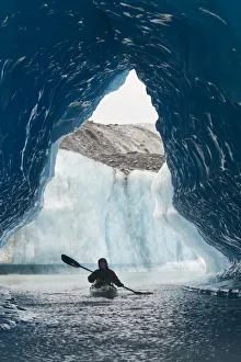 Sea Kayaker Paddles Through An Ice Cave Amongst Giant Icebergs Near Bear Glacier In Resurrection Bay Near Seward Sea Kayaker Paddles Through An Ice Cave Amongst Giant Icebergs Near Bear Glacier In Resurrection Bay Near Seward