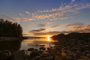 Seine fishing boats with sunset reflecting golden light on water and rocky shoreline, Alaska, USA Seine fishing boats with sunset reflecting golden light on water and rocky shoreline, Alaska, USA