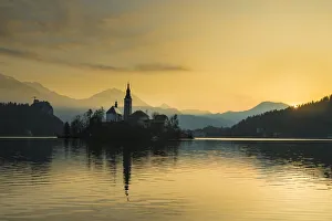 Silhouette of church and other buildings on Lake Bled at dawn; Bled, Slovenia Silhouette of church and other buildings on Lake Bled at dawn; Bled, Slovenia