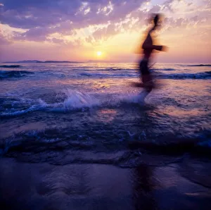 Silhouette Of A Man Running On Beach At Sunset; Ireland Silhouette Of A Man Running On Beach At Sunset; Ireland