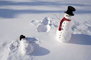 Snowmen In Forest Making Snow Angel Imprint In Snow In Late Afternoon Sunlight Alaska Snowmen In Forest Making Snow Angel Imprint In Snow In Late Afternoon Sunlight Alaska