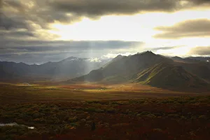 Sunlight Filtering Through Storm Clouds Illuminating The Fall Colours And Mountains Of The Cloudy Range Along The Sunlight Filtering Through Storm Clouds Illuminating The Fall Colours And Mountains Of The Cloudy Range Along The