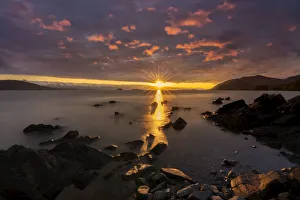 Sunset reflecting golden light on Lynn Canal with is silhouetted rock formations, Alaska, USA Sunset reflecting golden light on Lynn Canal with is silhouetted rock formations, Alaska, USA